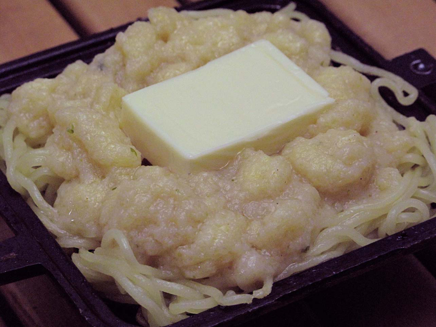 3:麺を敷き、その上にスナック菓子を練った生地、チーズを乗せ、さらにその上に麺を覆いパリパリに焼く。